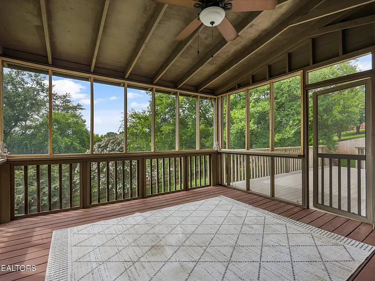 Screened porch overlooking mature trees and fenced backyard at 11016 Calloway View Dr